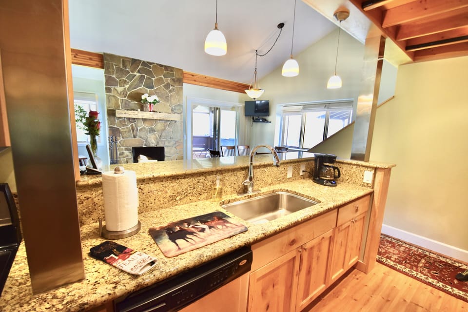 Kitchen looks into living room and beautiful views