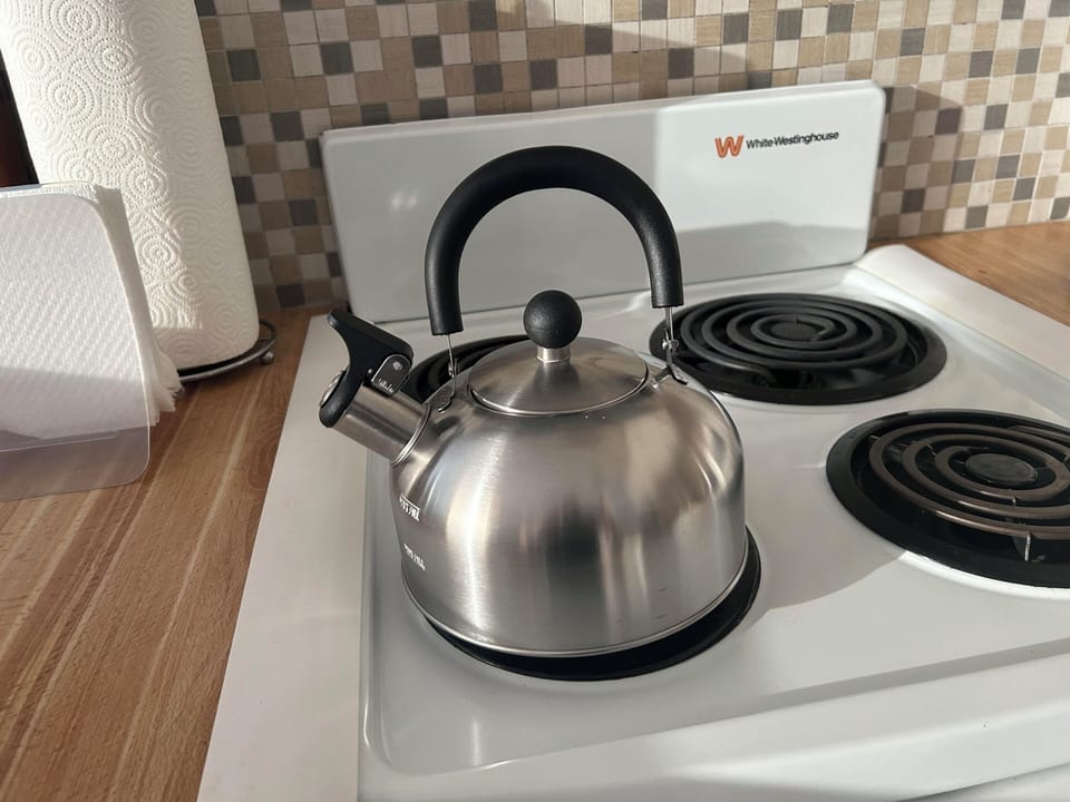 Tea Kettle located above the refrigerator cabinet.