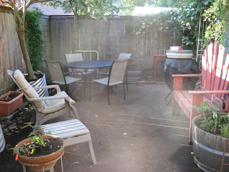 private patio with gas grill and a barrel of cherry tomato plants