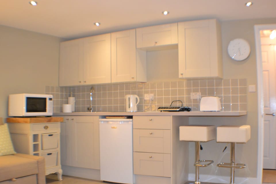 Kitchen with kettle, toaster, oven, hob, microwave, fridge, washing machine,