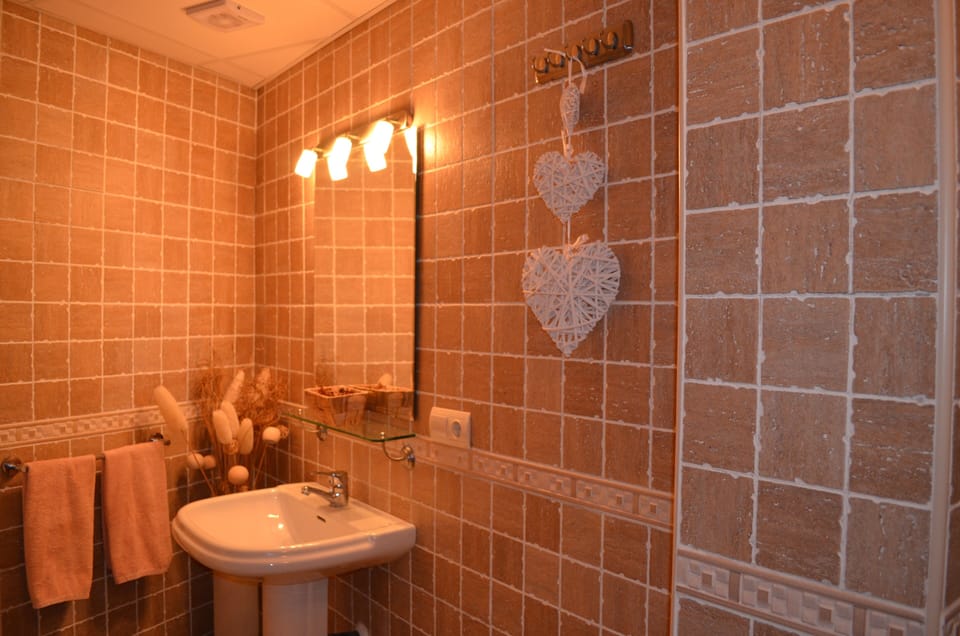 Corner of the large main bathroom which includes a bath, shower toilet and bidet
