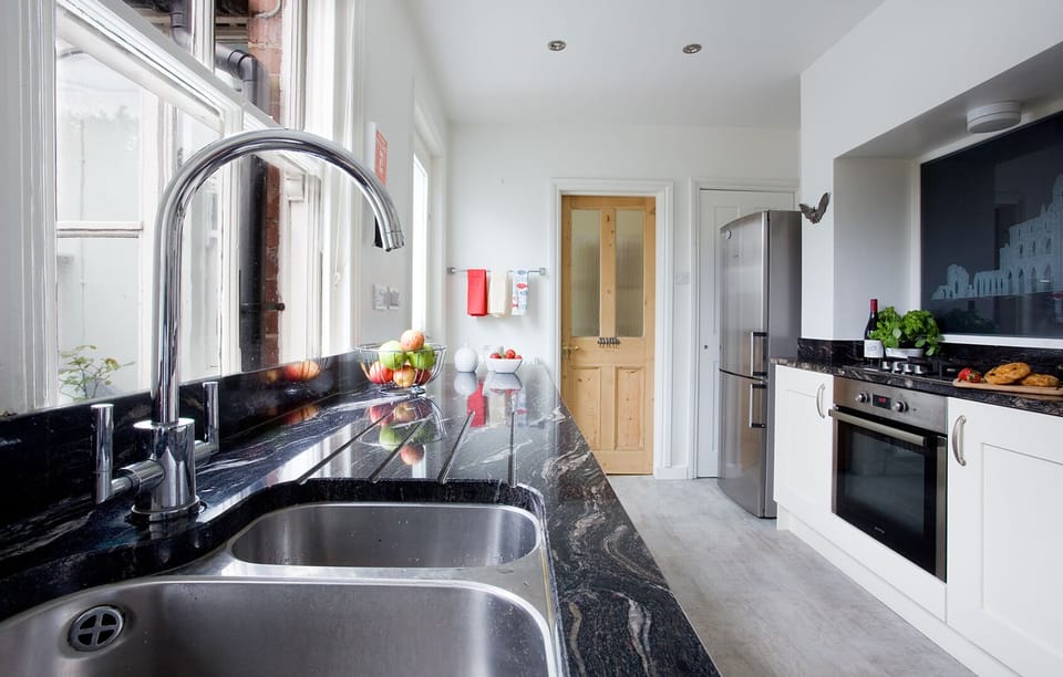 Kitchen with gas hob, electric oven, dishwasher, washing machine, microwave etc
