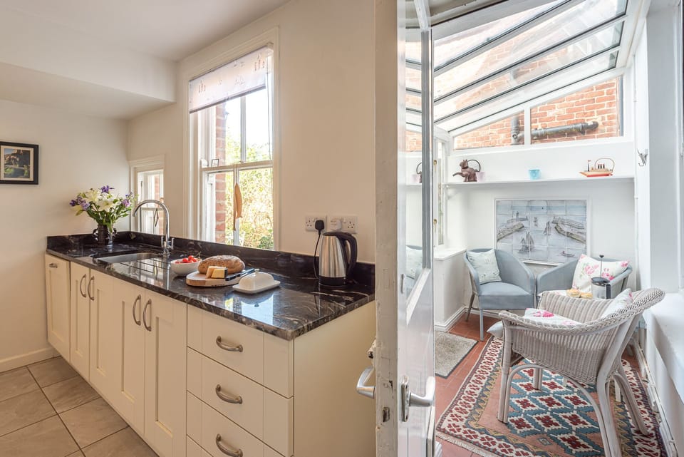 Kitchen opens into sunny conservatory
