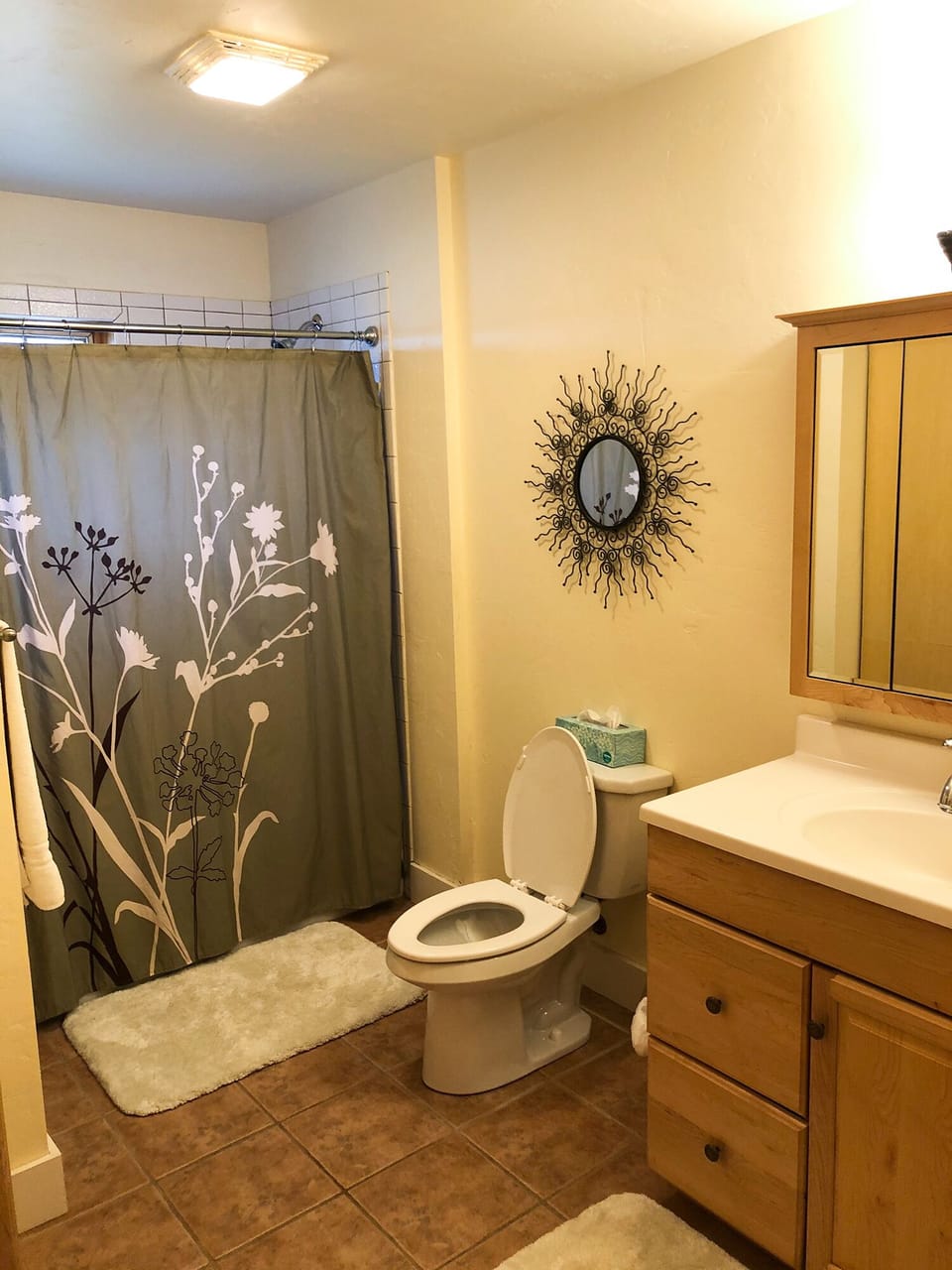 Guest bathroom with tub, shower, sink, toilet & extra linens