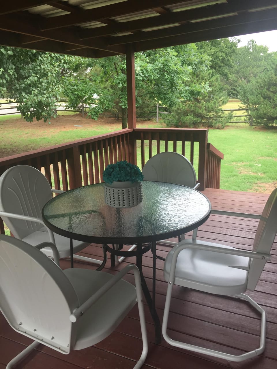 Large deck surrounded by a beautiful front yard.