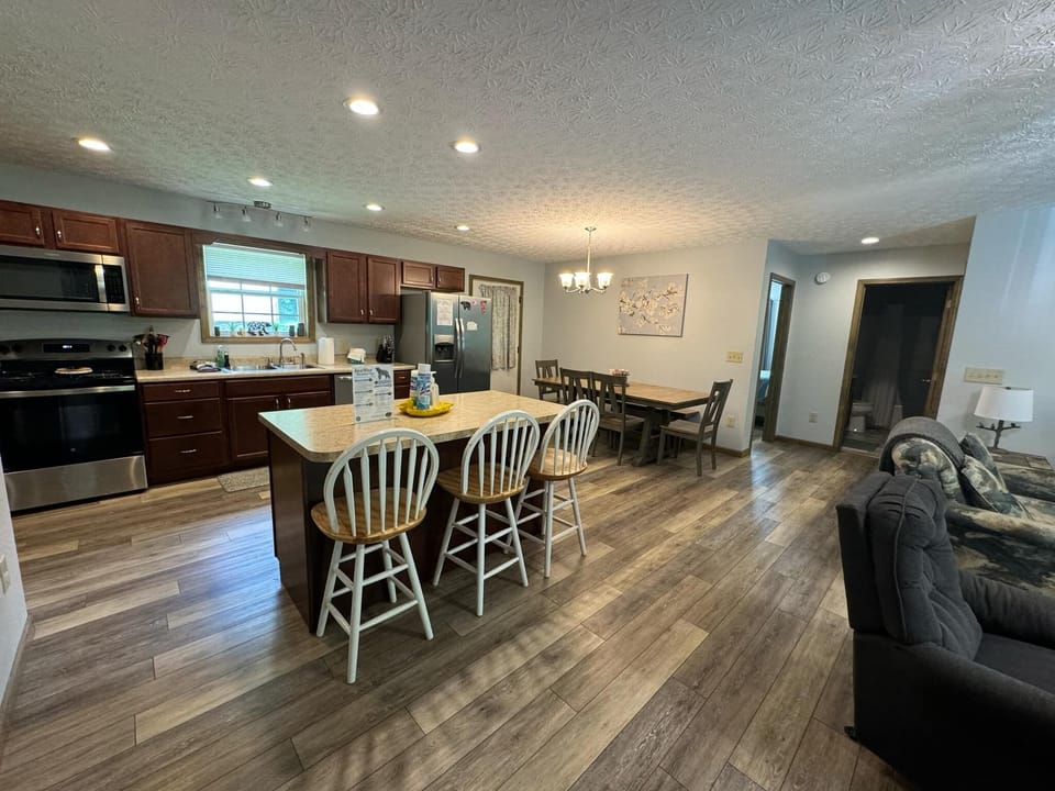 Kitchen island with barstool seating, door leads to back porch 