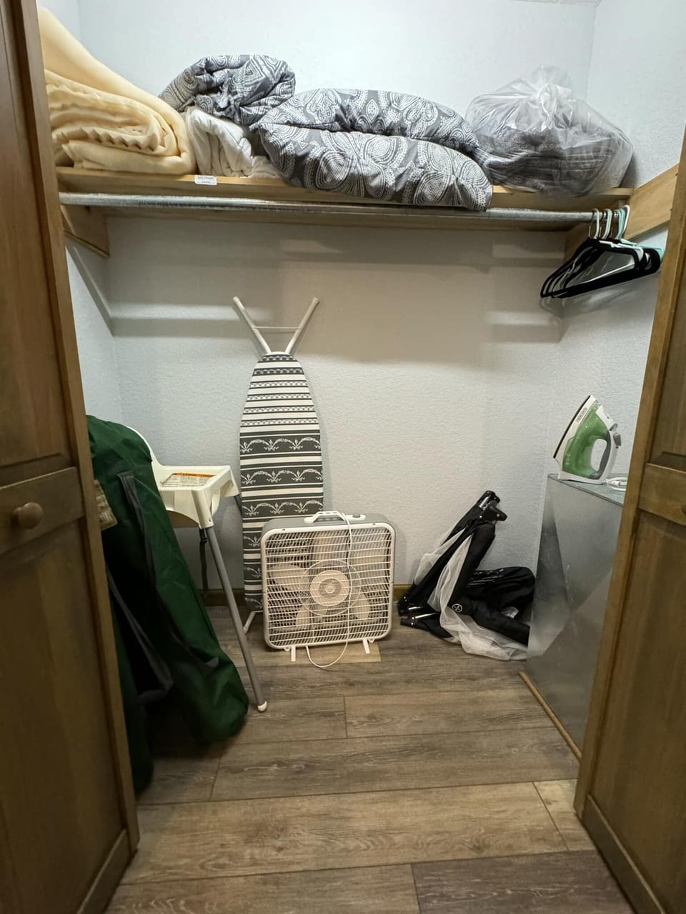 Master bedroom closet (ironing board, iron, fan, pack n play, highchair, linens)