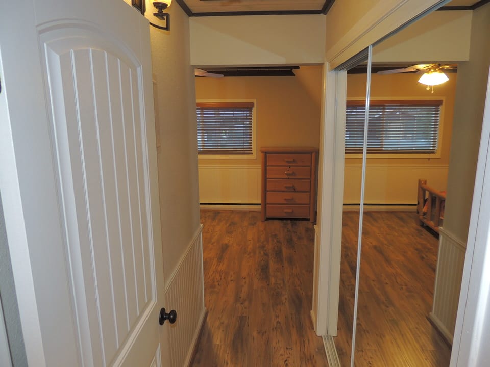 Hallway to bedroom and bathroom. Mirrored closet doors with linens, pillows