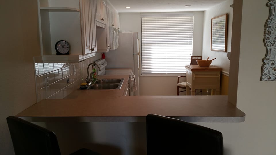 Kitchen view w/ counter top seating.