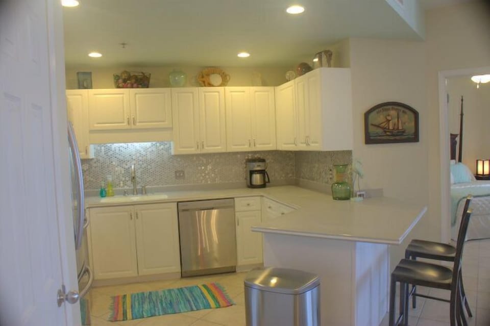Sea foam ceiling paint, stainless, & indirect lighting make for a bright space.