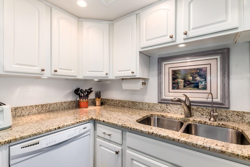 Tons of kitchen cabinets with lots of bright lights
