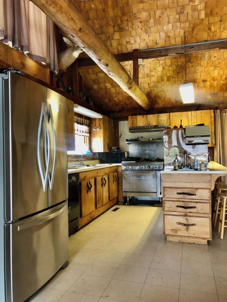 Galley style kitchen w/ industrial gas stove, dishwasher & large refrigerator. 