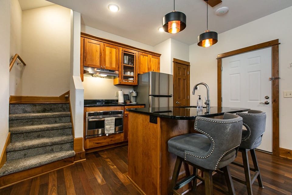 Full kitchen with stainless steel appliances, granite counters and eat in bar.
