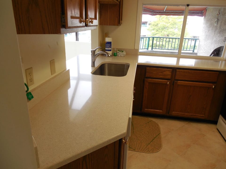 Kitchen with quartz countertops with view to outside balcony
