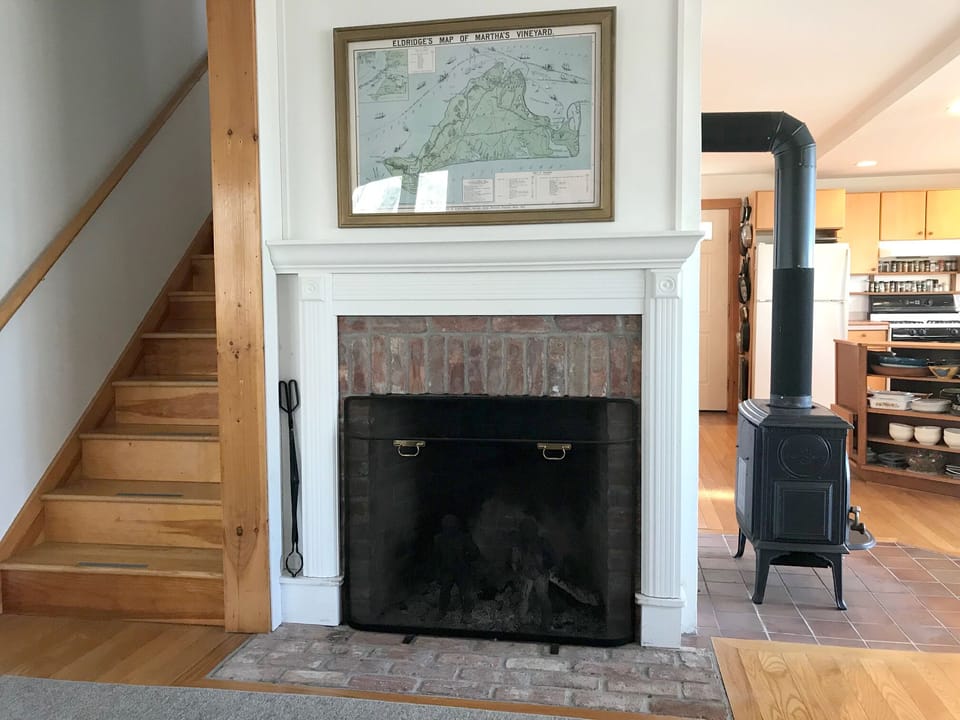 Wood stove and fireplace in living room with lake and ocean views 