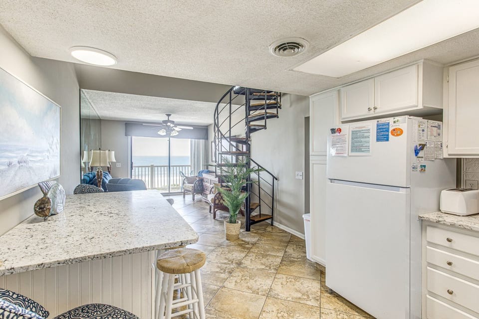 The view from the kitchen shows the den with glass doors to the large deck.