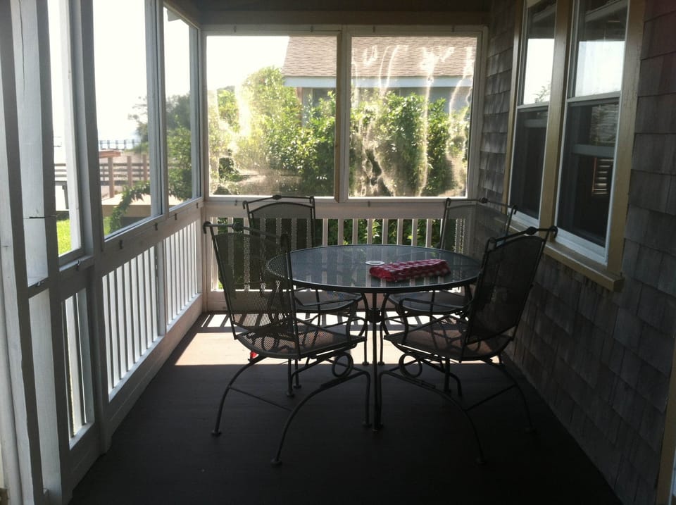 Screened in seating area overlooking the Sakonmet Bay. 