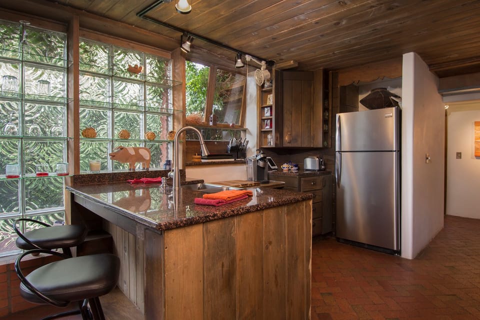 Block-Glass lit kitchen with granite counter top and leather bar stools.