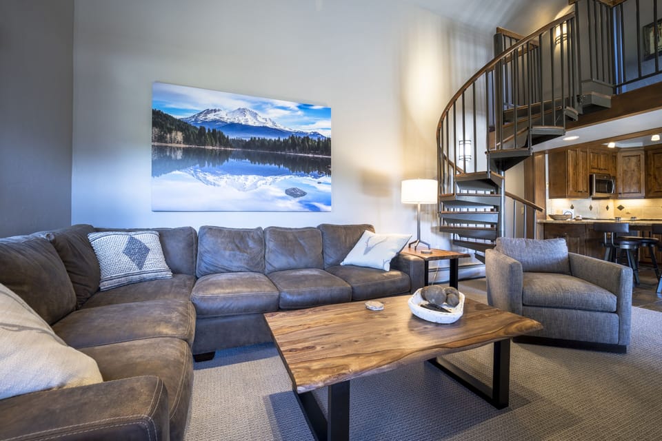 Spacious living room with staircase to loft area and 3rd bedroom.