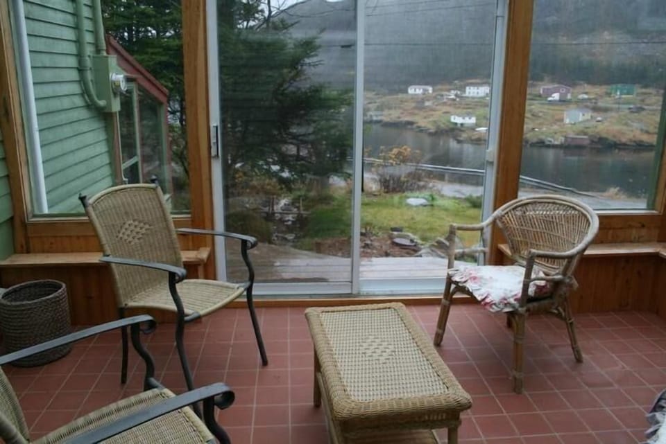 The Conservatory and deck with a view of the front lawn and harbour.