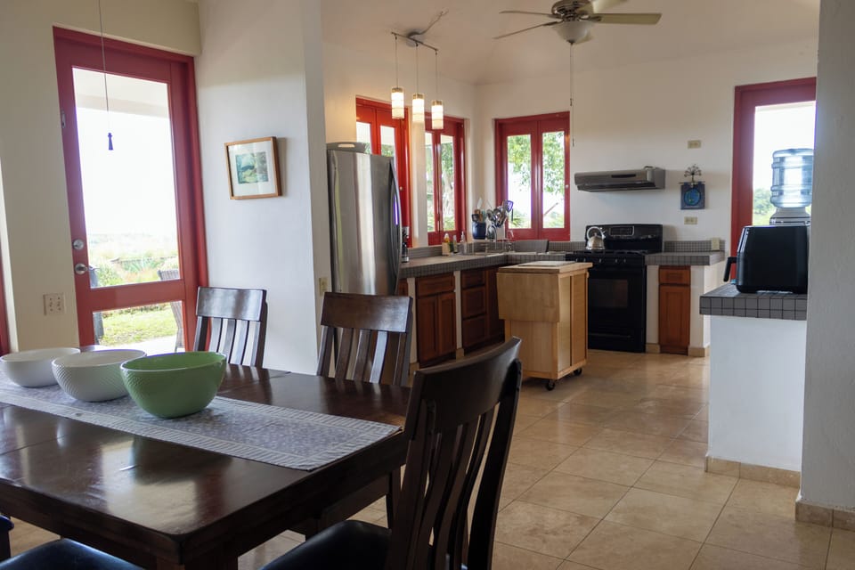 Indoor dining room looking into kitchen area