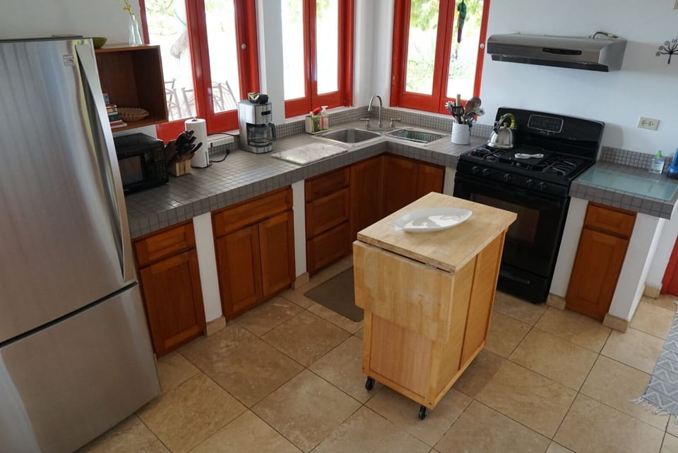 Kitchen has views of pool area, coastal mountains and ocean
