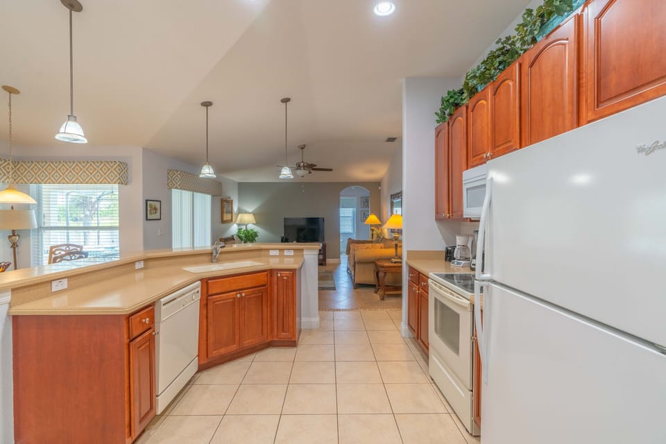 Kitchen, all appliances open with dining table and access to pool deck.