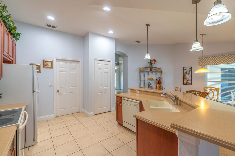 Kitchen, all appliances open with dining table and access to pool deck.