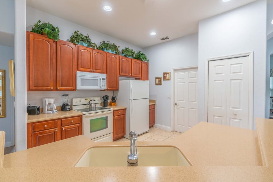 Kitchen, all appliances open with dining table and access to pool deck.