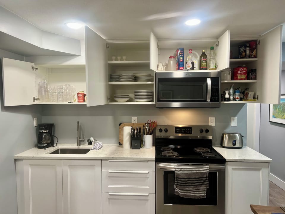 Well stocked kitchen with lots of dishes, pots/pans, crock pot, popcorn popper..