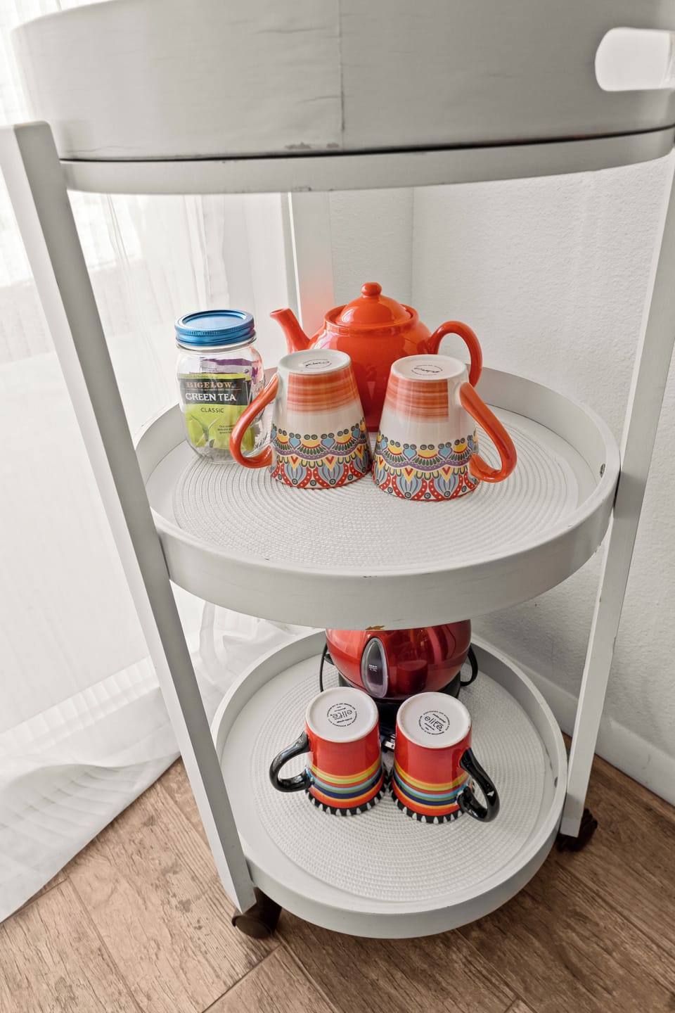 Tea cart: kettle, teapot, mugs, curated tea selection.