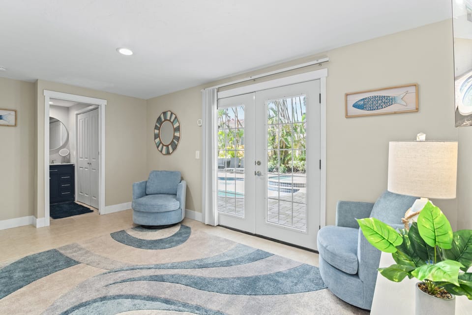 Ground floor mini living room.  Double doors lead to pool and patio area.