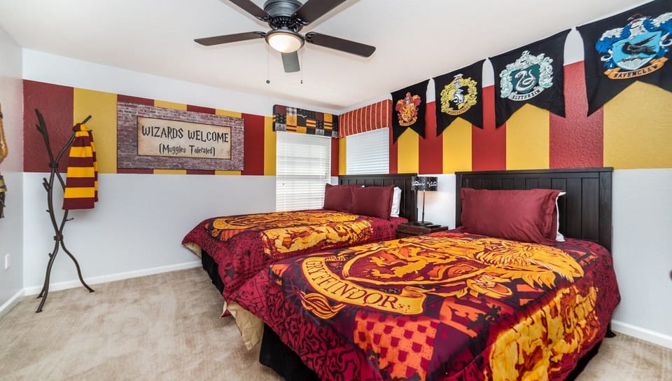 Magical wizard-themed bedroom with house banners, vibrant decor, and cozy twin beds.