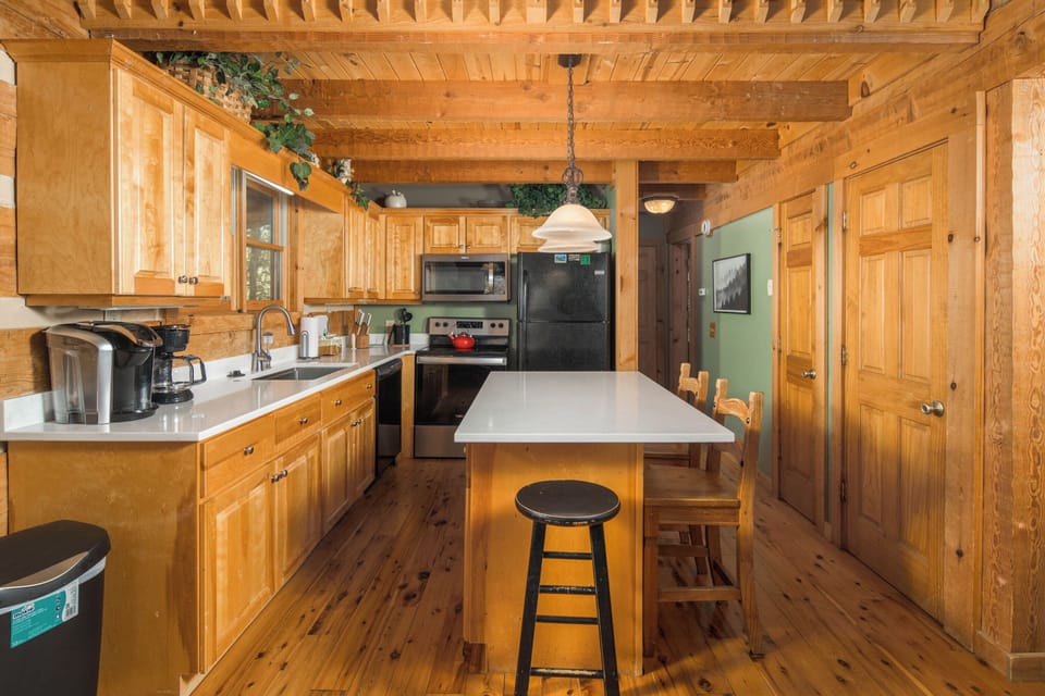 Fully equipped mountain cabin kitchen with rustic wood finishes and spacious island seating