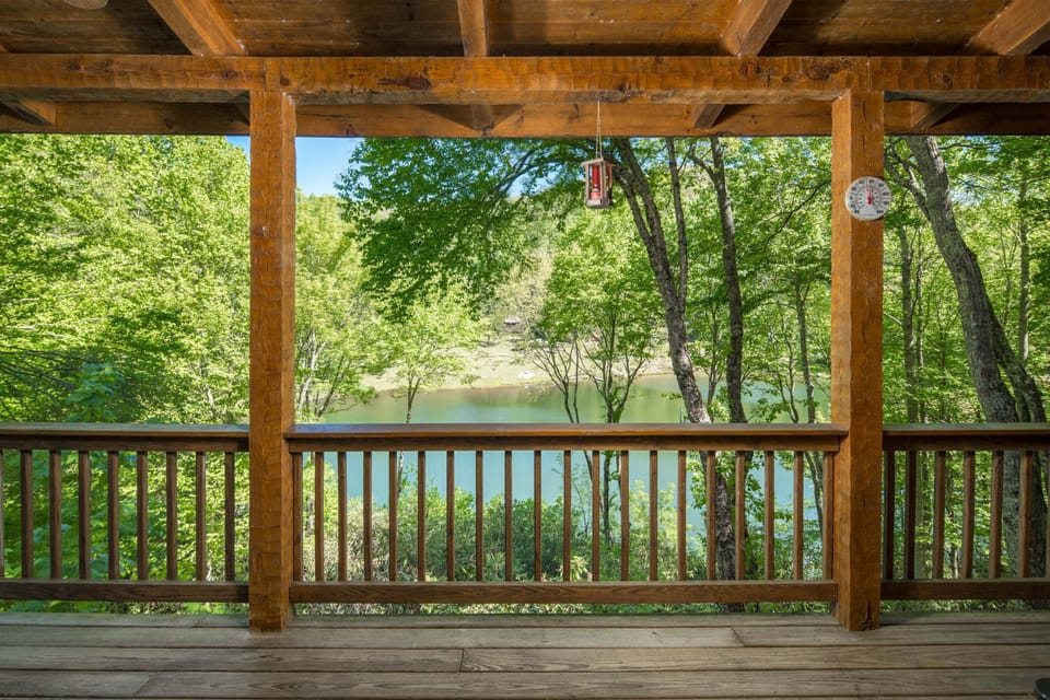 Relax on the covered deck overlooking peaceful lake and wooded mountain views