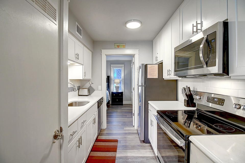 Your sleek galley kitchen awaits with stainless steel appliances, crisp white cabinets, and everything you need to create memorable meals.