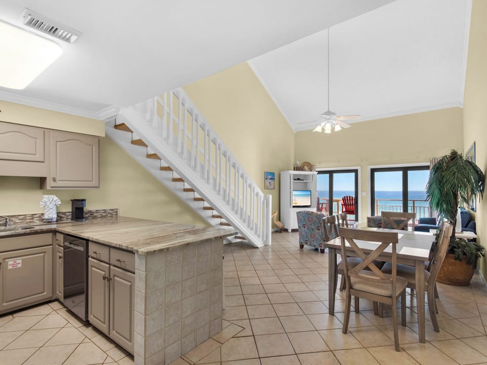 Open-concept living space where you can cook, dine, and relax while enjoying stunning ocean views through sliding glass doors.