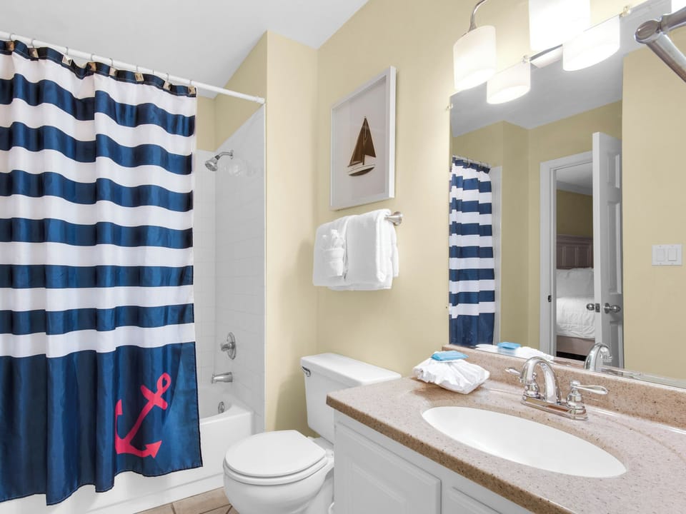 Your private bathroom features a relaxing tub-shower combo with nautical charm, plus soft towels and coastal décor for your comfort.