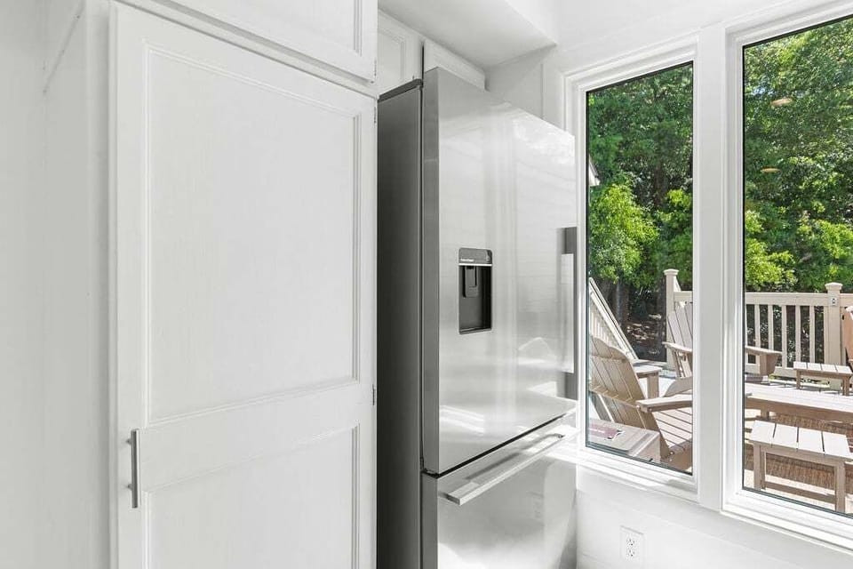 Stainless steel fridge and large pantry closet to store essentials