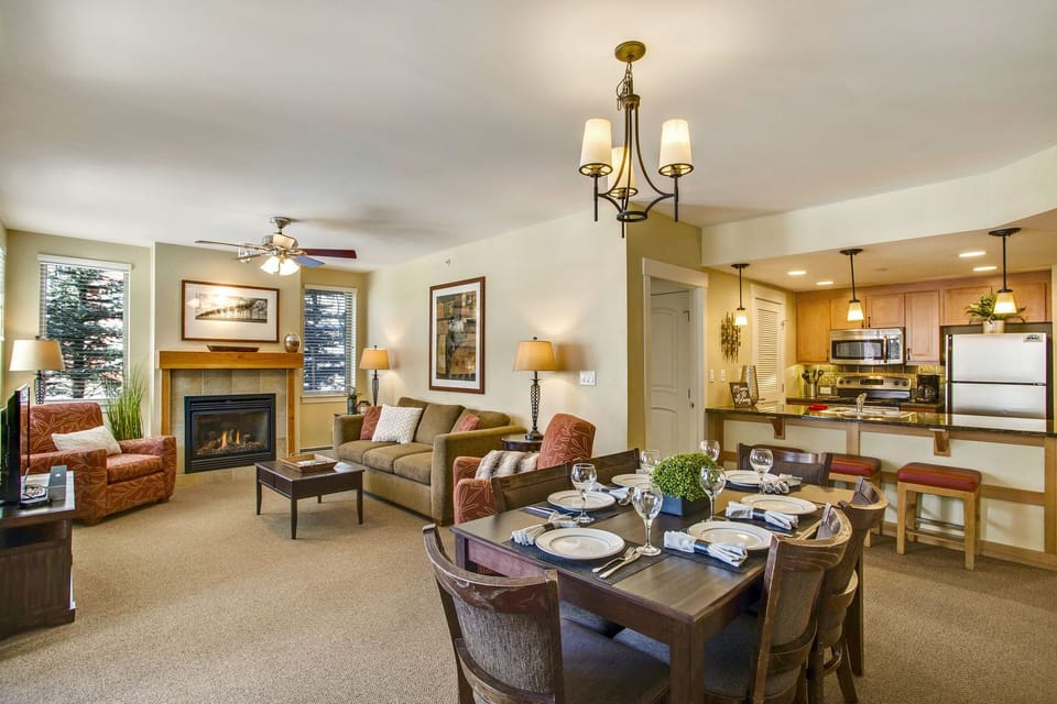 Arm Chairs, Sofa, Fireplace, TV, Ceiling Fan, Dining Table, and Chairs.