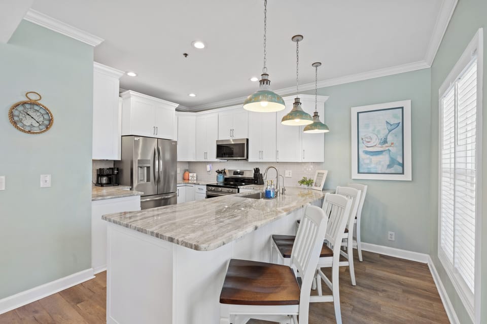 Bright coastal kitchen with large island seating and stainless appliances