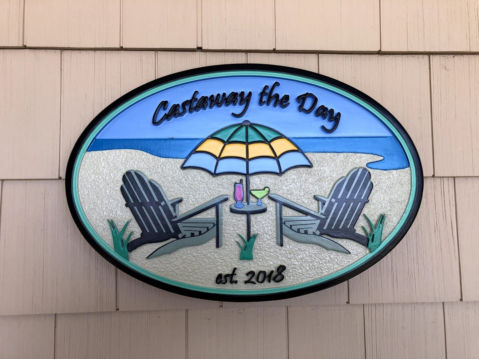 Charming coastal welcome sign with laid-back beach-house vibes