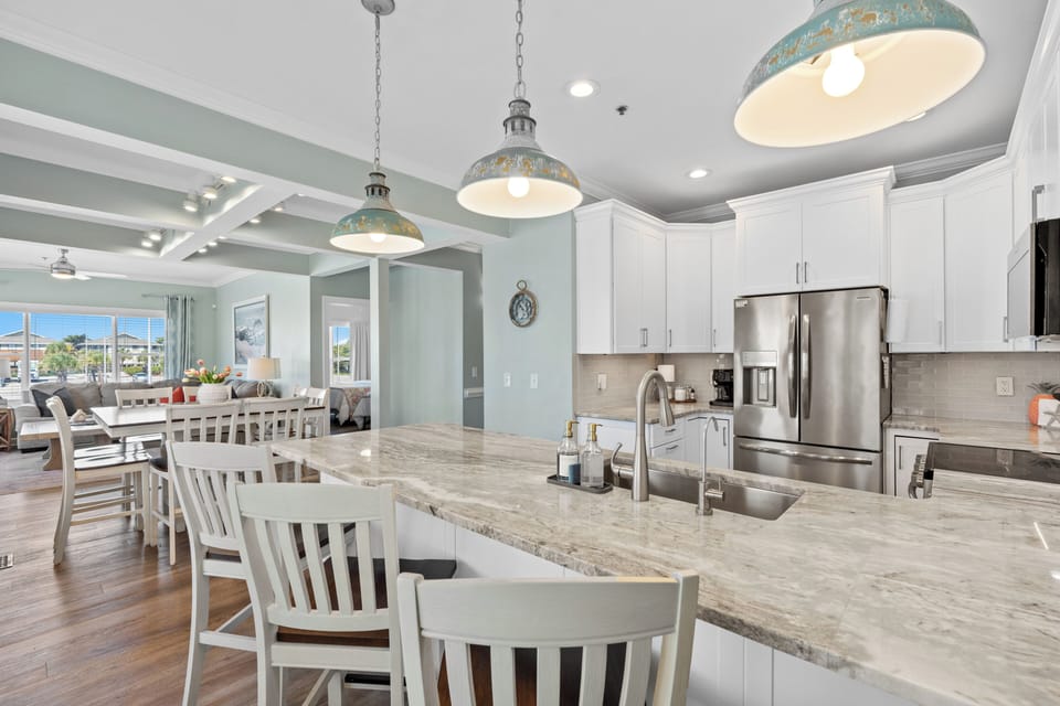 Bright coastal kitchen with large island, dining space, and open layout