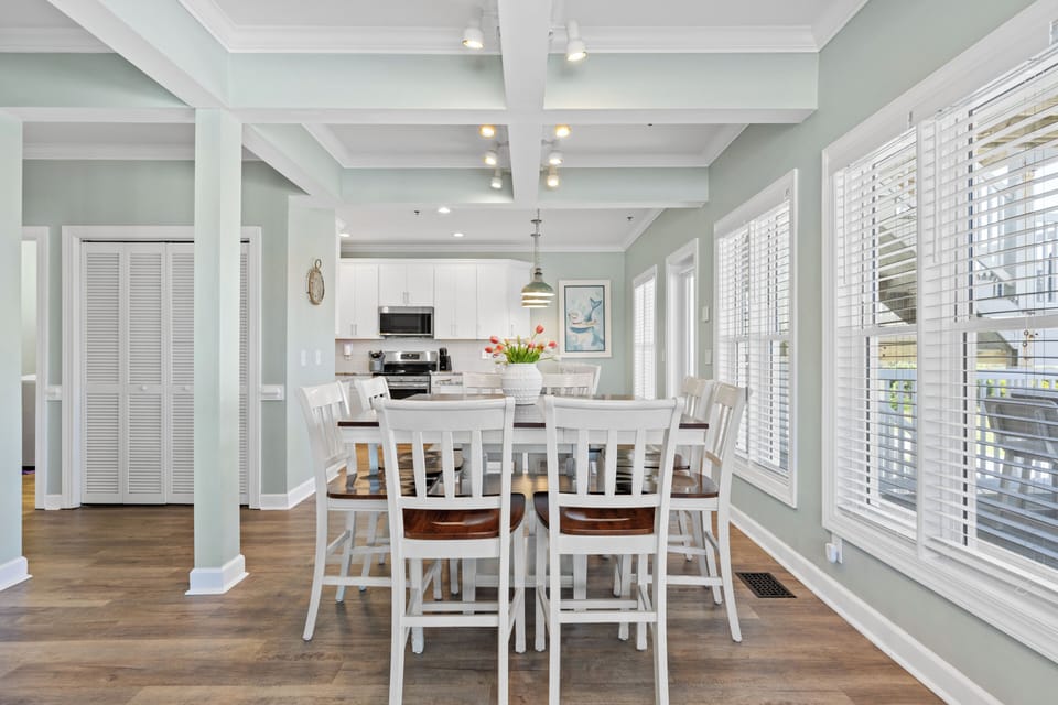 Bright coastal dining space with seating for 8 and open kitchen