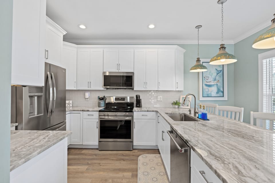 Bright coastal kitchen with marble-look counters and stylish bar seating