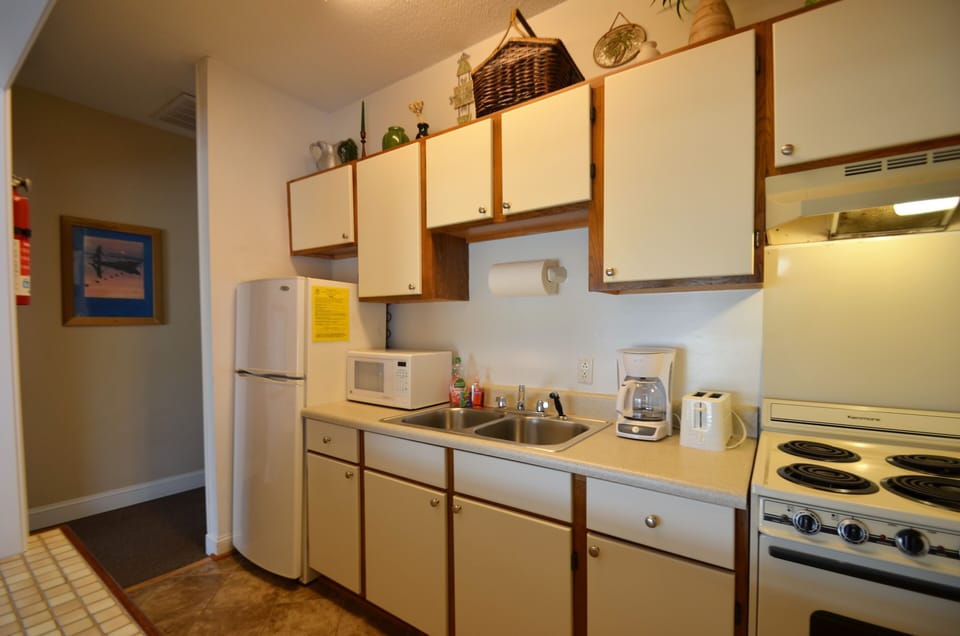 Galley kitchen with ceramic tile floor and open pass through to dining area