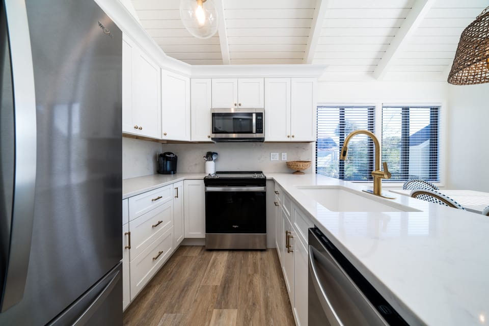 The lovely kitchen has custom cabinets, Quartz counters and stainless steel appliances