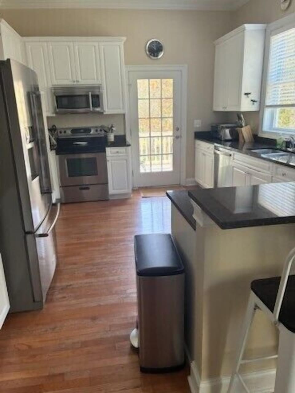 The kitchen features granite counters, custom cabinetry, and seating for 4.