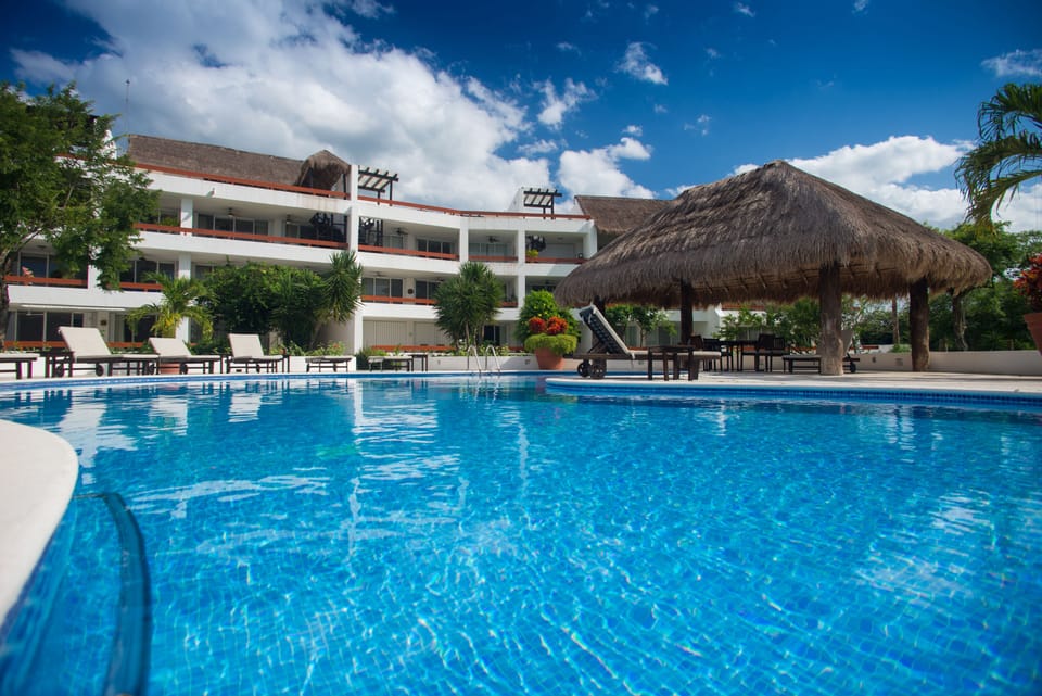 Resort pool retreat right off patio, our condo is center privately behind tree.