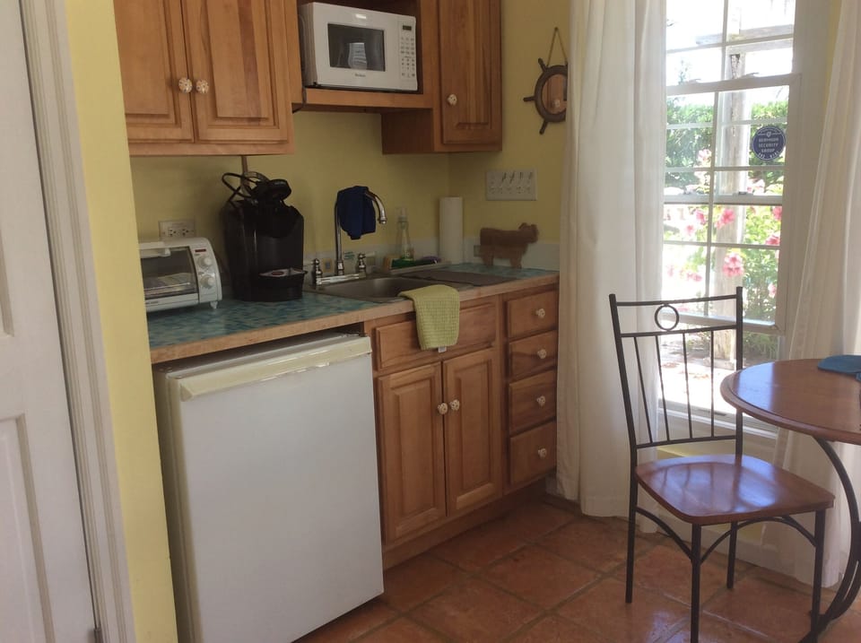 Kitchen includes a small fridge, microwave, toaster oven, and electric kettle 